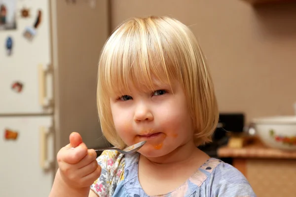 Blond dziewczynka zjada jedzenie łyżeczką — Zdjęcie stockowe