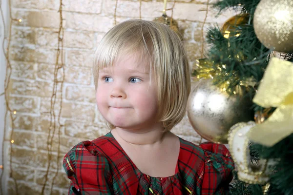 The little blonde girl standing near a Christmas tree — Stock Photo, Image