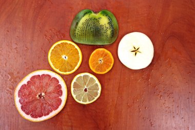 kırmızı ahşap masa üzerinde çeşitli dilimlenmiş meyve