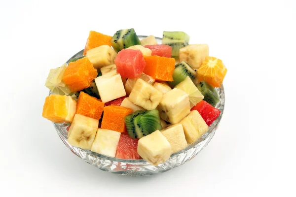 Ανάμεικτα φρούτα ψιλοκομμένα σε κύβους σε ένα πιάτο σε άσπρο φόντο — Φωτογραφία Αρχείου