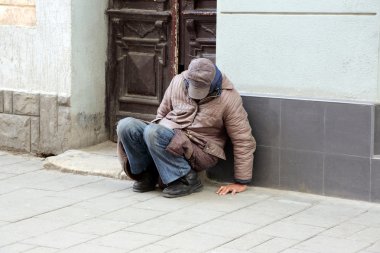 Bina duvara yakın oturan zavallı evsiz adam