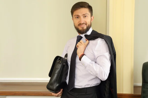 Hombre de negocios exitoso con un maletín y un traje en las manos — Foto de Stock