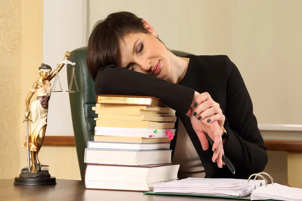 tired woman lawyer in the office with books and documents