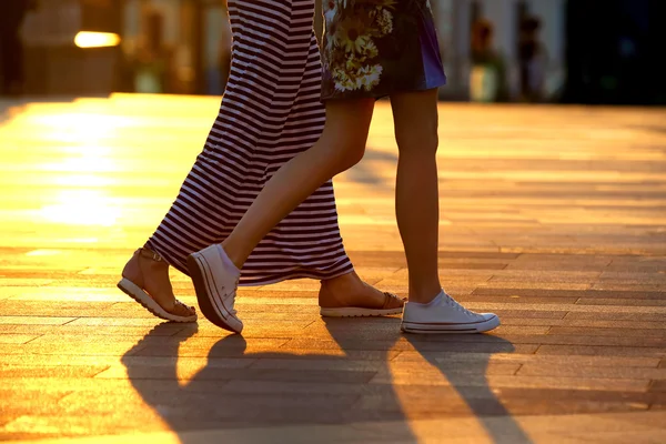 Ноги двох людей, що ходять на фоні сонячного світла — стокове фото