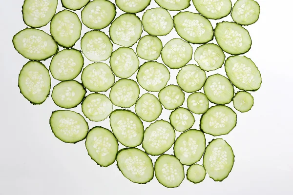 Cortar rodajas delgadas de pepino sobre un fondo blanco transparente — Foto de Stock