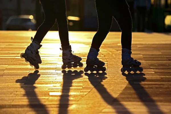Silhouette of two pairs of legs on roller skates — Stock Photo, Image