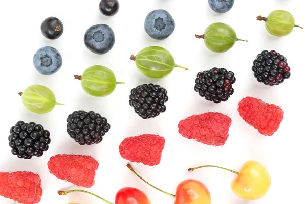 Различные сочные ягоды выкладываются рядами на белом фоне — стоковое фото