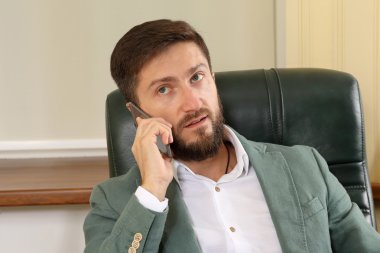 Ofisinde cep telefonu olan başarılı bir iş adamının portresi.