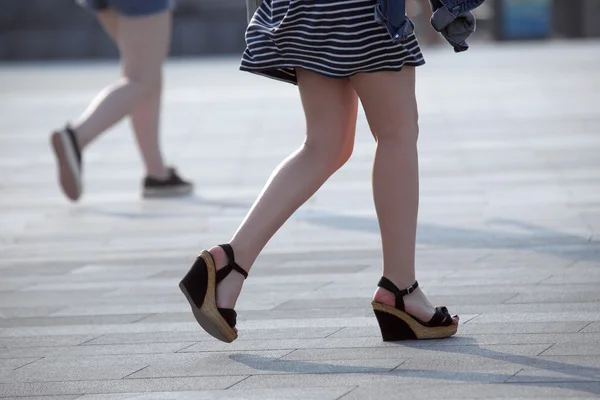 Caminar piernas de las mujeres en la luz del sol contraluz — Foto de Stock