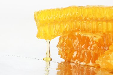 hafif bir arka plan üzerinde peteğin üzerinden akan bal