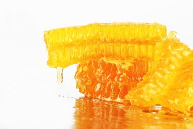 hafif bir arka plan üzerinde peteğin üzerinden akan bal