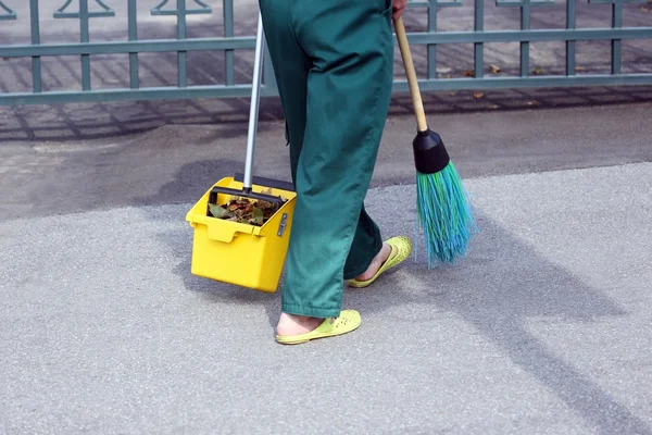 The janitor swept the city sidewalk from the fallen leaves — Stock Photo, Image