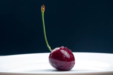 Sulu kiraz böğürtlenleri beyaz bir tabakta yatıyor. Kahvaltıda sağlıklı yemek. Bitkilerin meyveleri. meyve tatlısı