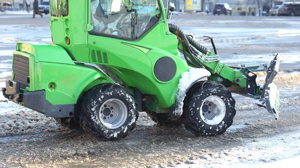 street cleaning the city from snow with the help of special equipment mini