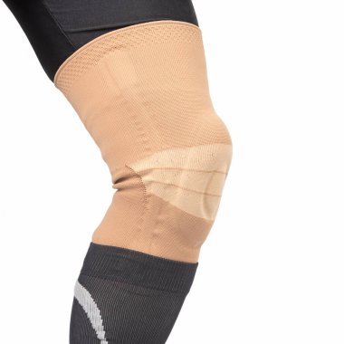 Beyaz arka planda insan bacağının yaralı dizini tedavi etmek için bandaj. Tıp ve spor. uzuv yaralanması tedavicileri