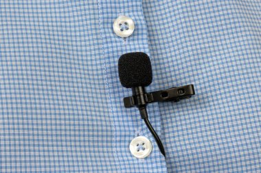 Yoğunlaştırıcı mikrofondan ses kaydı. Lavalier mikrofon yakın plan bir gömleğin klipsiyle korunuyor..
