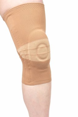 Beyaz arka planda insan bacağının yaralı dizini tedavi etmek için bandaj. Tıp ve spor. uzuv yaralanması tedavicileri