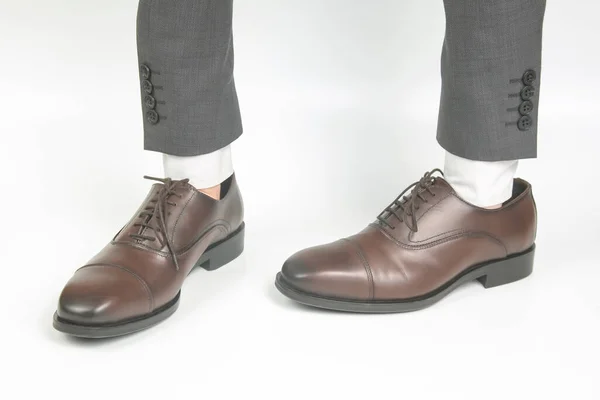 白い背景に手に身に着けている古典的な茶色の革の靴 — ストック写真