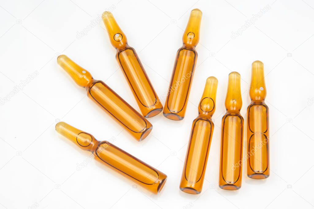 seven medical glass ampoules for injection drug on a white background