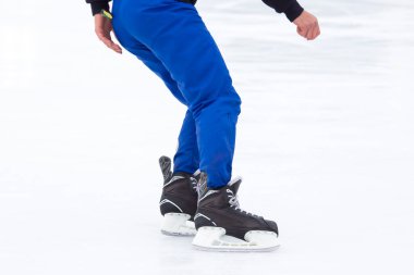 Buz pateni pistinde kayan bir adamın bacakları. Hobiler ve boş vakitler. kış sporları