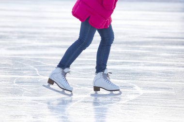 Mavi kotlu ve buz pistinde beyaz patenli bir kadının bacakları. Hobiler ve boş vakitler. kış sporları