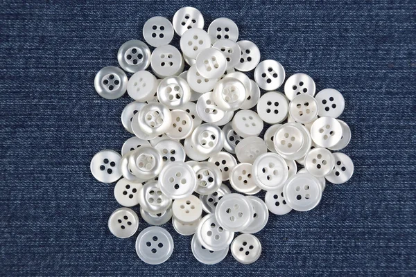 Plastic shiny buttons for clothes on a fabric background. Fashion and clothing. Factory industry