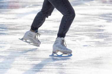 Buz pateni pistinde yuvarlanan birinin ayakları.