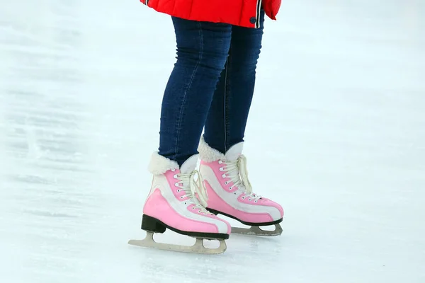 Legs of a woman skating on an ice rink. Hobbies and sports. Vacations and winter activities