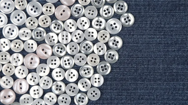 Plastic shiny buttons for clothes on a fabric background. Fashion and clothing. Factory industry