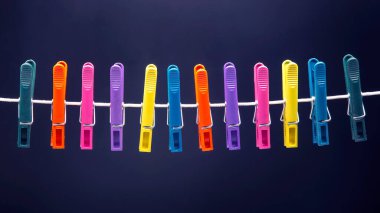 İpte asılı renkli plastik mandallar.