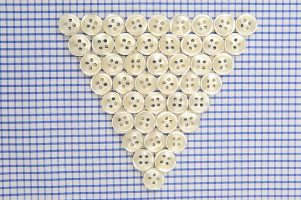 Plastic shiny buttons for clothes on a fabric background. Fashion and clothing. Factory industry