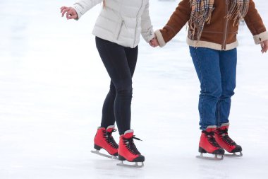 Buz pateni pistinde kayan farklı insanların ayakları. Hobiler ve boş vakitler. kış sporları