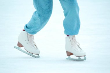 Buz pateni pistinde buz pateni yapan bir kadının bacakları. Hobiler ve boş vakitler. kış sporları