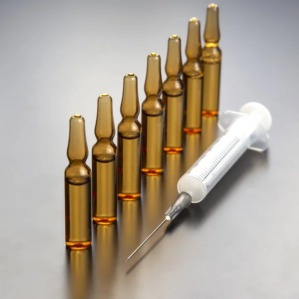 seven medical glass ampoules for injection drug on a gray background
