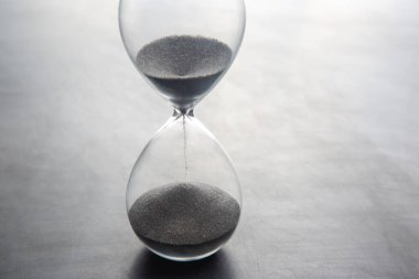 Hafif bir arka planda kum saati. Vakit nakittir. İş çözümleri zamanında.