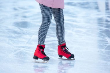 Buz pateni pistinde buz pateni yapan bir kadının bacakları. Hobiler ve boş vakitler. kış sporları