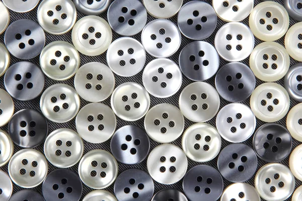 Plastic shiny buttons for clothes on a fabric background. Fashion and clothing. Factory industry