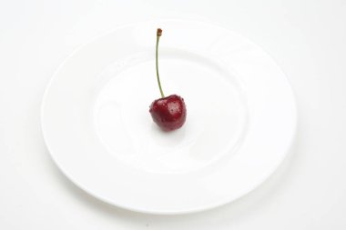 Sulu kiraz böğürtlenleri beyaz bir tabakta yatıyor. Kahvaltıda sağlıklı yemek. Bitkilerin meyveleri. meyve tatlısı