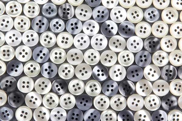 Plastic shiny buttons for clothes on a fabric background. Fashion and clothing. Factory industry