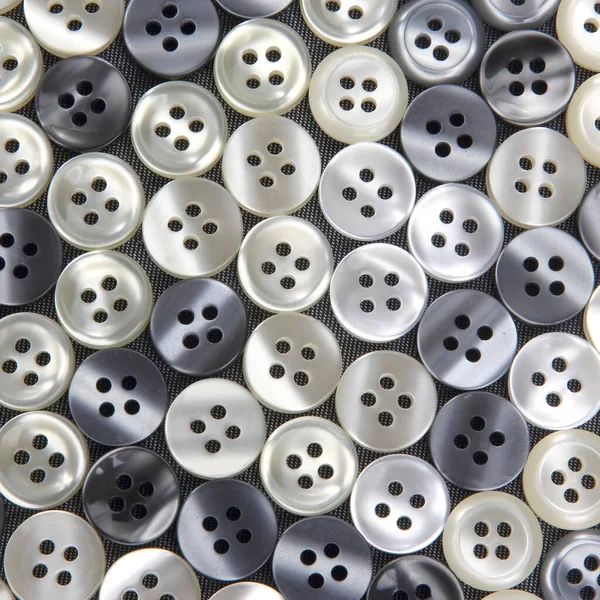 Plastic shiny buttons for clothes on a fabric background. Fashion and clothing. Factory industry