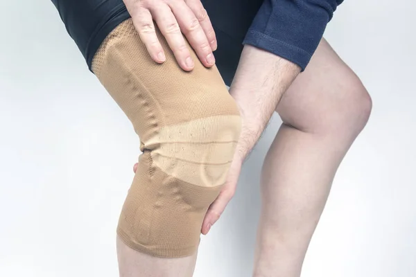 bandage for fixing the injured knee of the human leg on a white background. medicine and sports. limb injury treatment