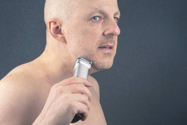 Sakalını düzeltmesi için sakallı bir adam. Tımar ve modaya uygun bir berber dükkanı. Sakal uzunluğu düzeltmesi