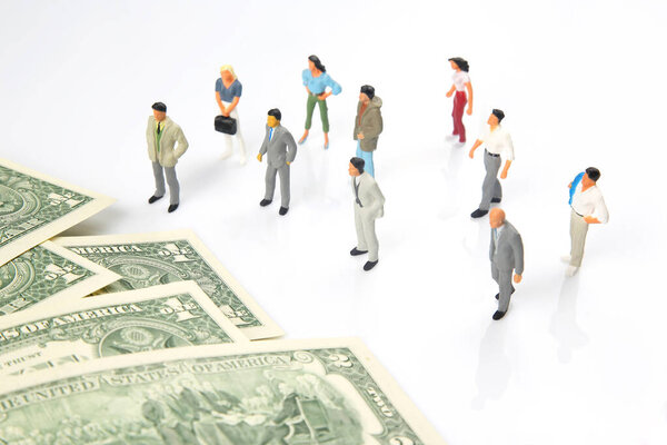 miniature people. different businessman stands near dollar money. investments and earnings for work