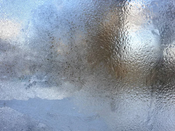 frosty patterns on the window glass closeup. natural textures and backgrounds. ice patterns on frozen