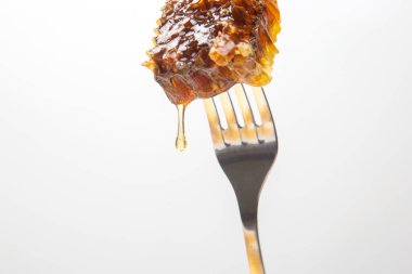 Masa çatalına bal damlatan taze bal damlaları. Vitamin ve arı ürünleri.