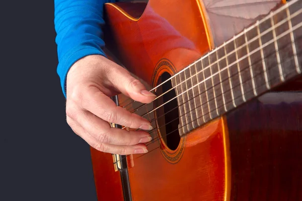 male guitarist hands with nails while playing music. classical guitar