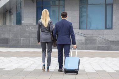 İş ortakları erkek ve kadın birlikte yürür ve diyalog kurarlar.