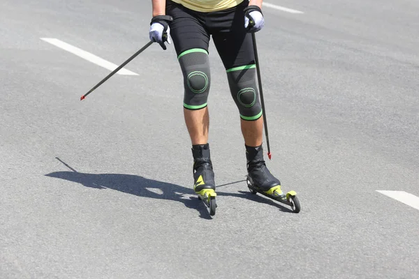 sportsman roller skis on the asphalt on the city road. Sports leisur