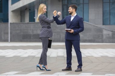 İş ortakları erkek ve kadın birbirlerini elleriyle selamlarlar.
