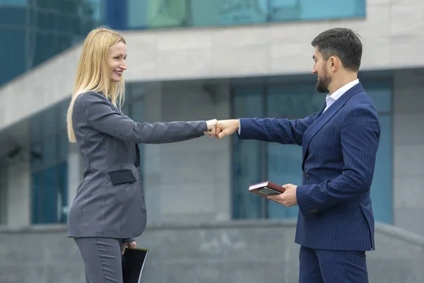 business partners man and woman greet each other with their hand